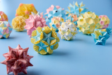 Set of multicolor handmade modular origami balls or Kusudama Isolated on blue background. Visual...