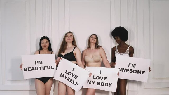 Four beautiful women holding signs with positive self affirmations