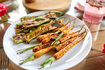 Grilled carrots and zucchini on plate on the dinner table