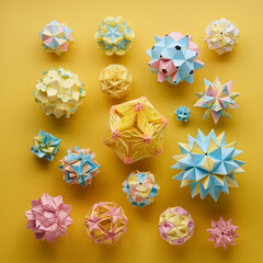 Set of multicolor handmade modular origami balls or Kusudama Isolated on yellow background. Visual...