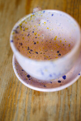 Ceramic cups on a pink saucer on a wooden table