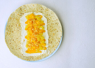 quick tacos snack with pineapple, mango, peanuts, cream cheese and banana spread. Comfortable food, dessert burrito