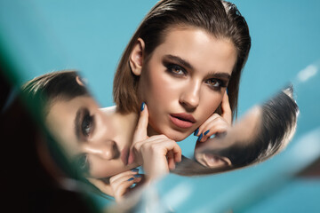 Nineties. Portrait of young female fashion model with reflection on mirrors around her face....