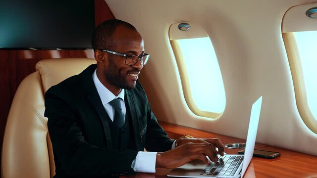 Successful entrepreneur using laptop on his private jet
