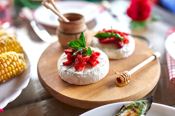 Grilled camembert cheese with strawberry, honey and basil leaves, delicatessen