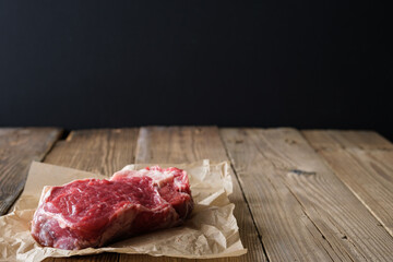 Raw meat on wooden board with dark background