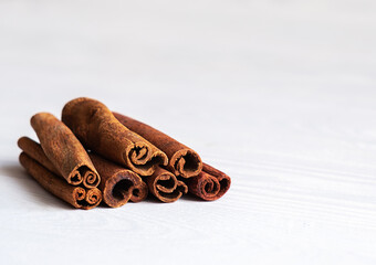 Aromatic spice. Cinnamon sticks on light wooden background with place for text