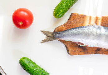Norwegian herring on a board on a white table

