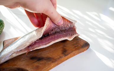 Norwegian herring on a board on a white table

