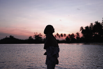 Fototapeta premium Standing alone woman silhouette on the beach