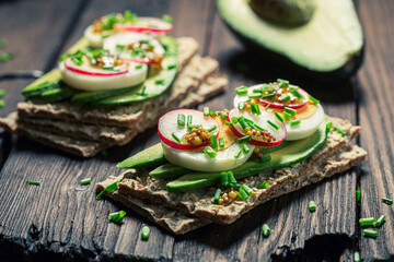Tasty sandwich with eggs, avocado and radish