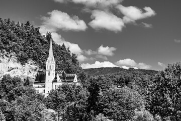 St. Martin church in Bled, Slovenia. Small white church surrounded by green trees on top of a rock hill