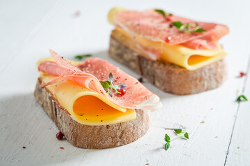 Delicious a piece of bread with cheese, ham and herbs