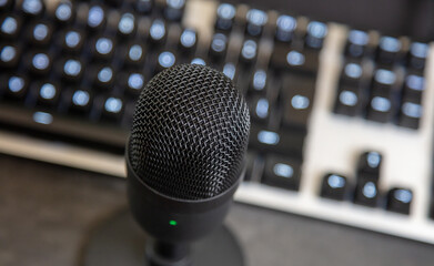 Microphone, mic condenser black metallic, blur keyboard background.