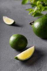 Juicy green limes on grey concrete background.