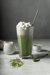 prepared matcha tea in a clear glass. a delicious drink made from Japanese green tea powder. vertical position