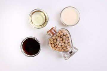 Soya beans in a hart shape glass bottle soya sauce milk oil in glass bowl on white background