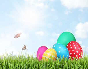 Bright Easter eggs on green grass outdoors, space for text