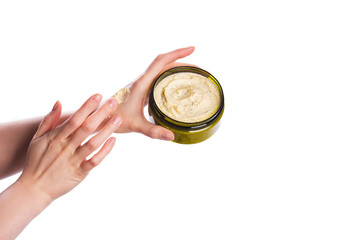 Jar of body cremy scrub for body in female hand isolated on white background, copy space for text