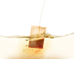 Dipping of tea bag into hot water against white background