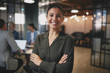 Confident young businesswoman smiling while standing in a modern office