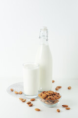 A glass with almond milk and the bowl with almonds