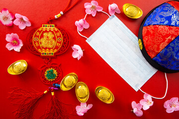 Face mask and Chinese ancient ingot and flowers on red color.