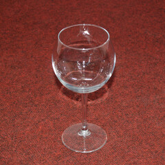 Glass empty high glass for drinks on a background of red cloth.