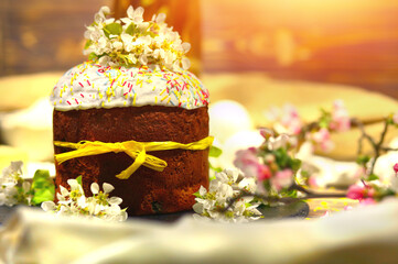Easter cake with sugar glaze and colored sweet sprinkles, decorated with white apple flowers....