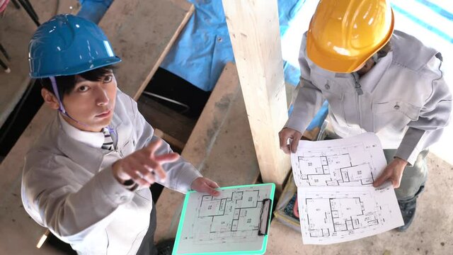 住宅建築現場で働く人々　スケルトンリフォーム　打ち合わせ　俯瞰