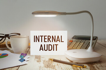 Desktop with a lamp that illuminates the inscription INTERNAL AUDIT