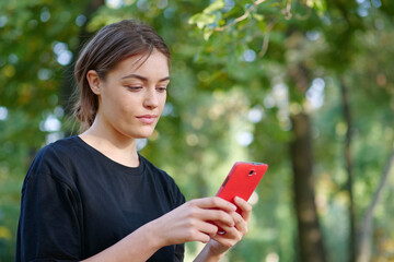 Beautiful young girl looks in smartphone