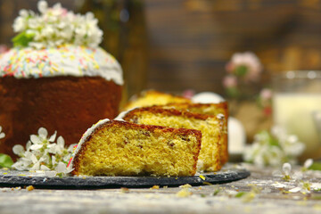 Happy Easter! Easter cake and slices next to it, on dark wood background. Homemade baking. Easter concept. Copy space on the right.