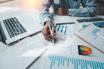 Business women sitting on a laptop and checking business graph documents, working in financial...