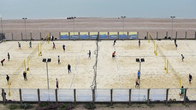 Grupo de gente jugando a voleibol de playa en la playa de Brighton, Reino Unido, a orillas del mar