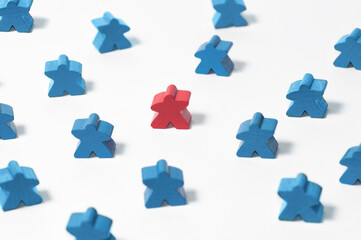 A toy red wooden figure of human in center others blue figures. Business recruitment, talent...