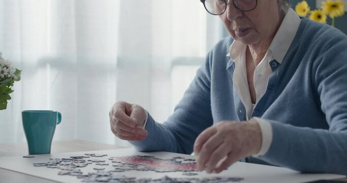 Elderly woman playing puzzle at home