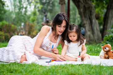 Mother with girl toddler having rest at park