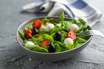 Fresh salad with mozzarella cheese, tomato and spinach. Healthy dieting food.