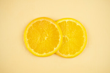 Sliced orange on yellow background