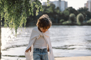 Portrait of a boy playing in nature near the river.