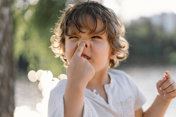 Portrait of a boy playing in nature near the river.