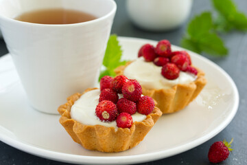 Wild strawberry tartlets with cream filling. delicious summer fruit mini tarts