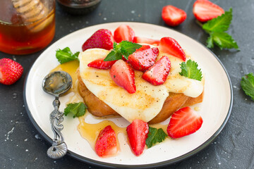 toast with grilled mozzarella, fresh strawberries and honey. Useful zavstrak.