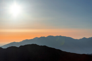 Obraz premium silhouettes of mountain ranges at sunrise background image