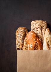 Assortment of baked bread, Crusty French Baguette, brown and white wheat grain loaves, seeds in...