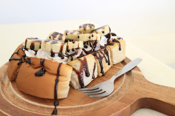 Close-up Bread bakery homemade toasted with chocolate and banana on wood plate.
