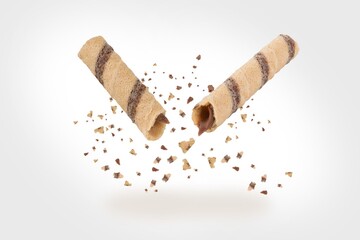 Delicious broken sweet waffle on grey background.  Waffle rolls stick, flying