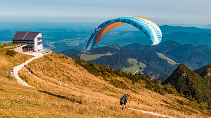 Beautiful alpine summer view with a paraglider at the famous Hochfelln summit, Bergen, Bavaria,...