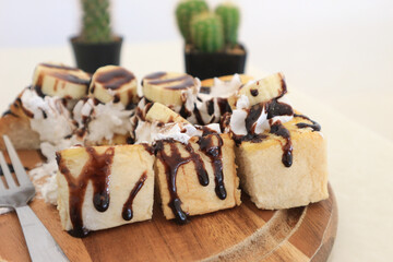 Close-up Bread bakery homemade toasted with chocolate and banana on wood plate.